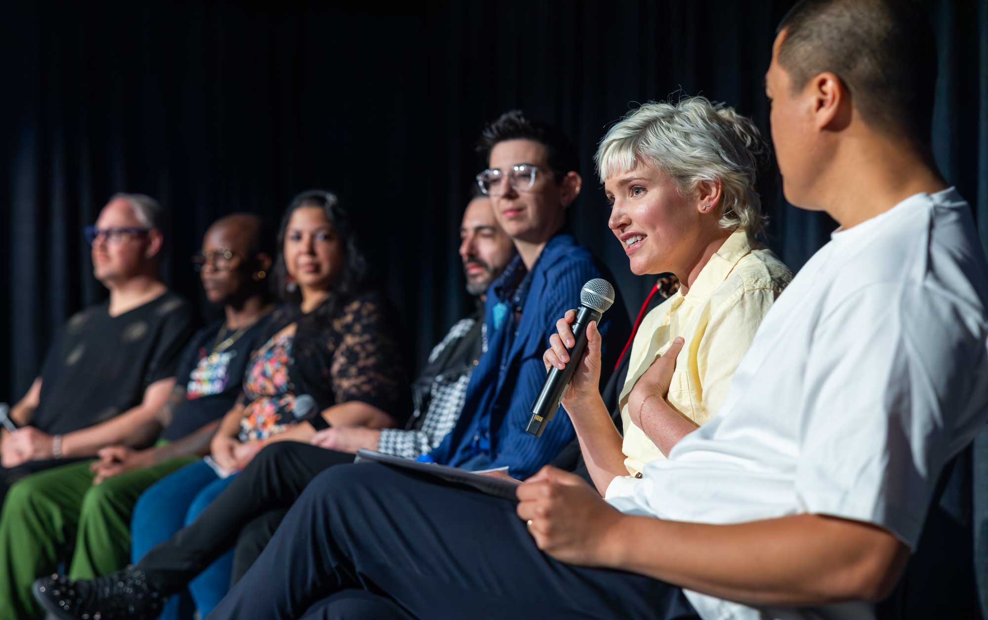 Woman on a panel speaking passionately at a conference