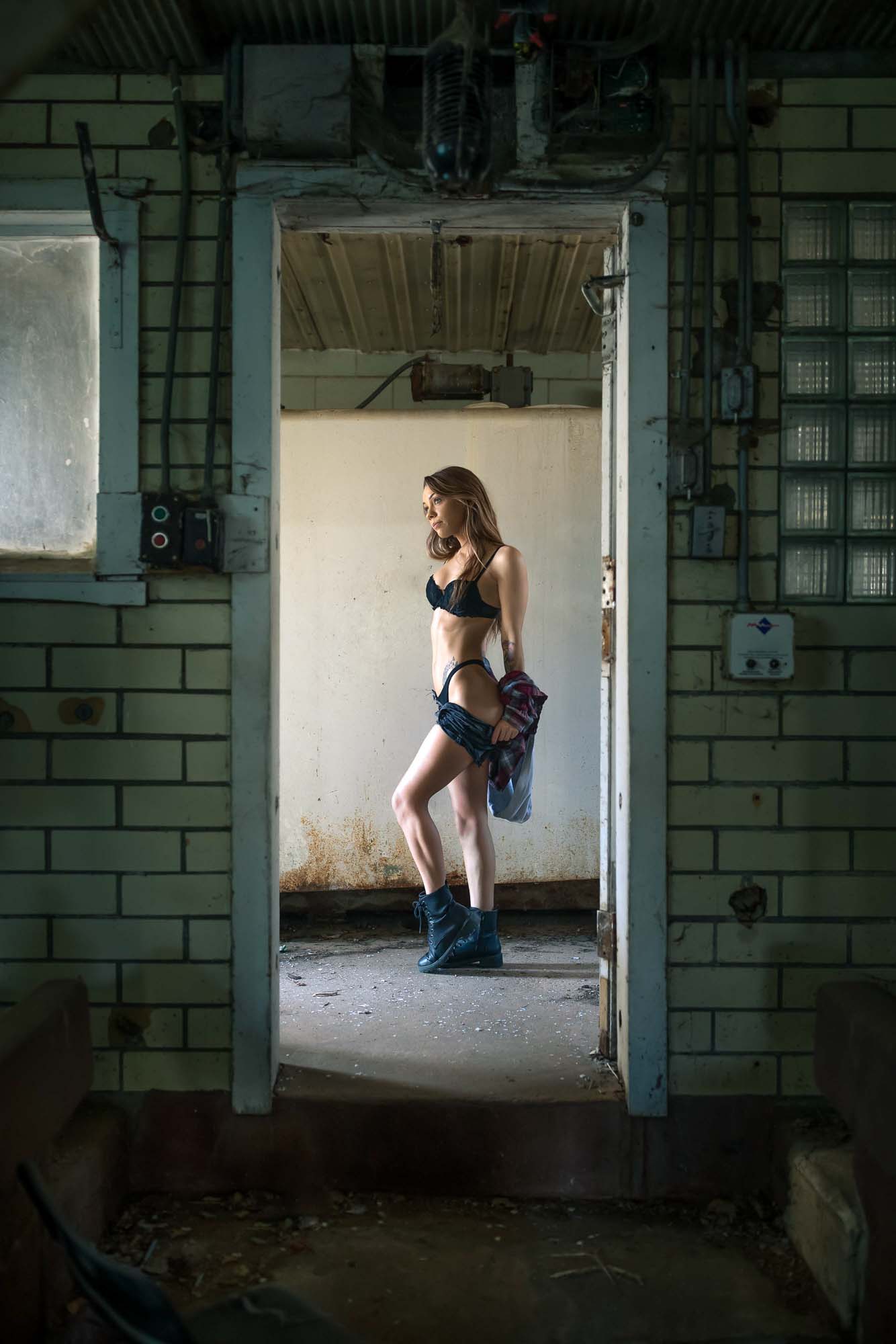 Edgy industrial fashion editorial of model @space.junkiee in the doorway of an abandoned Denver warehouse