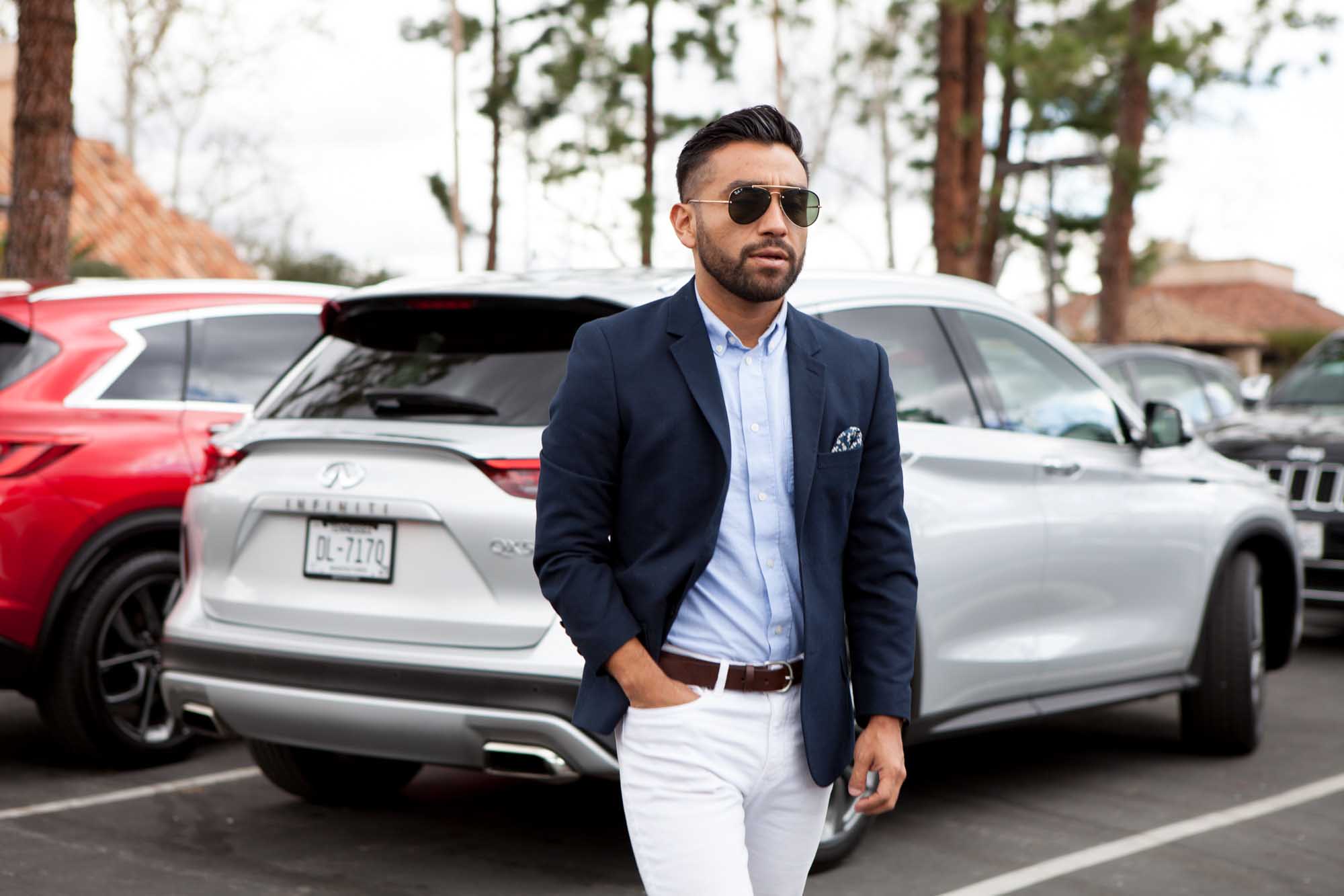 Lifestyle automotive photography for Infiniti featuring a man walking past an SUV
